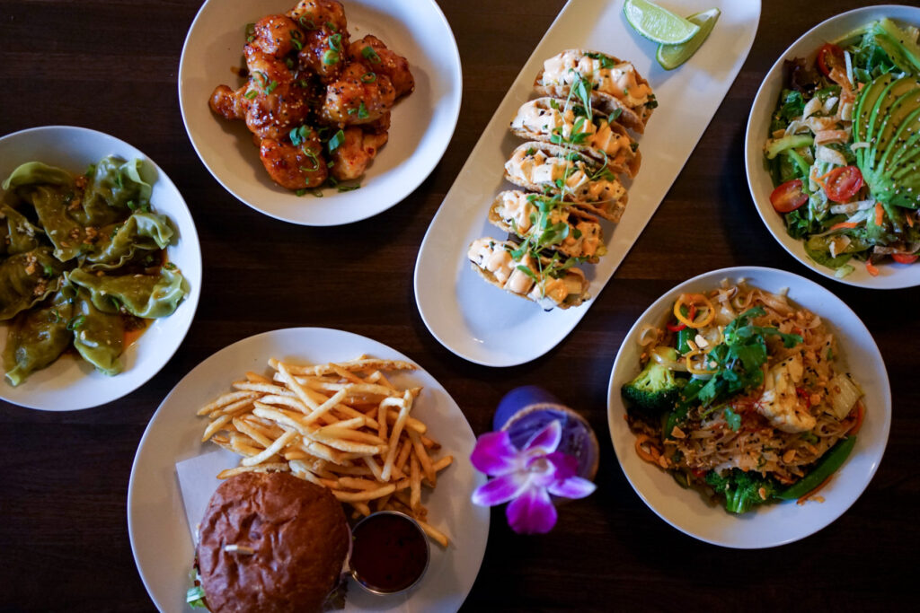 Bar Dojo vegan spread of dishes including tofu poke tacos, hoison cauliflower wings, a burger, and more